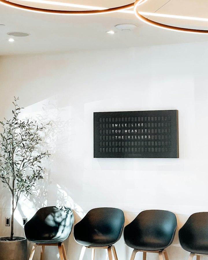 The waiting area, with a row of chairs, a plant and soft light.
